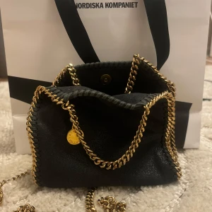 Stella McCartney Väska - Stella McCartney i färgen mörk blå. Det är i storleken tiny alltså det populäraste storleken! Köptes på Nk, kvitto och påse finns! Skriv vid frågor eller pris. Kedjan som du håller i har tappat lite färg precis som min förra Stella väska🥰
