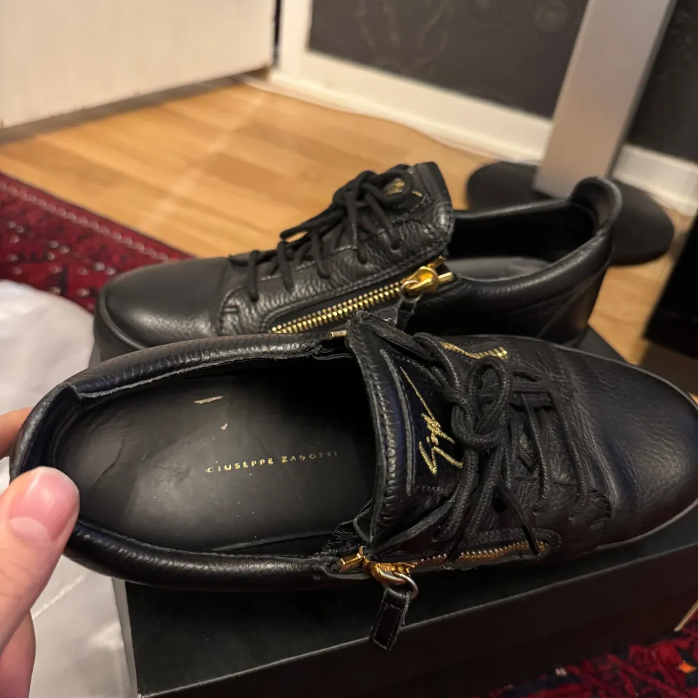 Snygga svarta sneakers i skinn från Giuseppe Zanotti med guldfärgade dragkedjor och snörning. Originella Dustbagen ingår. Skick är runt 8/10, de är sparsamt använda. Köpt från yoox där ord pris är 5200kr. Kengät.