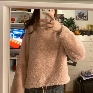 Rosa fluffig hoodie från H&M - Mysig rosa hoodie från H&M i fluffigt material. Den har en justerbar dragsko i nederkanten och långa ärmar. Jätteskön, men säljer då den inte kommer till användning. Tryck gärna på köp nu!! 💗💗