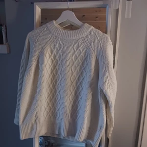 Vit stickad tröja från 157 - Mysig vit stickad tröja från 157. Tröjan har långa ärmar och en rund halsringning. Hör av dig vid frågor💗