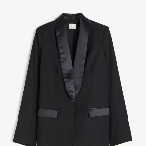 Svart kavaj med satin detaljer, H&M premium - Så snygg svart kavaj med glänsande satin slag och knappar. Helt oanvänd, klassisk passform med dom extra detaljerna ✨