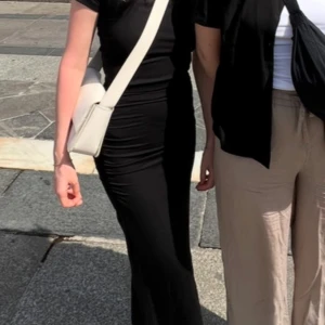 Svart kjol från Gina Tricot - Snygg svart långkjol från Gina Tricot i en tight passform. Kjolen är basic, vilket gör den lätt att matcha med olika toppar och accessoarer. Använd 1 dag utomlands. Resår på sidan.