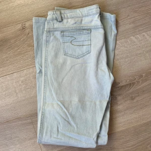 Ljusblå jeansbyxor - Snygga ljusblå jeansbyxor med klassisk femficksdesign och subtila sömmar på bakfickorna. Perfekta för en avslappnad stil.