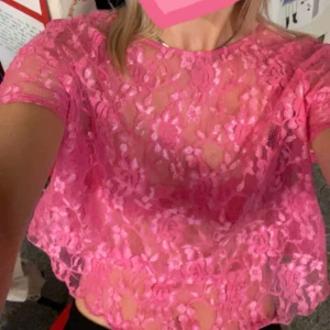 Rosa spetsblus  - Säljer en söt rosa spetsblus med korta ärmar och rund halsringning. Blusen har en dragkedja i ryggen och ett blommigt mönster. Står stl 40 men jag har haft den som XS/S.