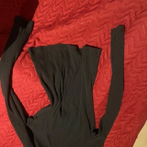 Svart ribbad tröja - Säljer en svart ribbad tröja med långa ärmar. Perfekt för en stilren look och passar bra till både jeans och kjol. Tröjan är i storlek 12/14 år och har en bekväm passform.