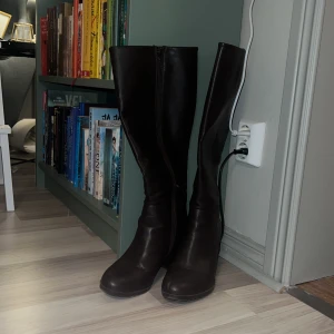 Bruna stövlar med klack - Snygga bruna stövlar i skinn med klack och dragkedja. Perfekta för höst och vinter, dessa stövlar ger en elegant touch till din outfit. 