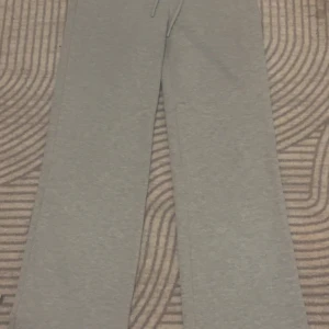 Grå mjukisbyxor - Säljer ett par bekväma grå mjukisbyxor med normal passform. Perfekta för en avslappnad dag hemma eller på språng. Byxorna har en enkel design med resår i midjan för extra komfort.