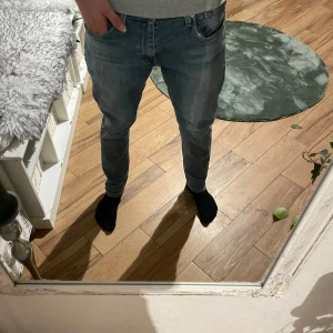 Levi's 512 jeans - Säljer ett par klassiska Levi's 512 jeans i en snygg blå färg. De har en slim passform och är midwaist. Perfekta för en stilren look.
