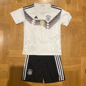 Retro Tyskland ställ - VM Retro Neuer Tyskland ställ, riktig bra julklapp eller present till dig själv. Tröjan har ett mönster på bröstet och ett FIFA-märke. Perfekt för fotbollsfans! Tyskland VM ställ Neuer.