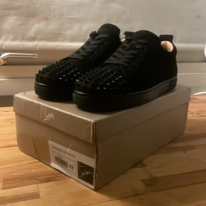 Svarta sneakers med nitar från Christian Louboutin - Skorna säljs för det inte kommit till användning och skorna är kopior och skicket är 10/10 endast använd 2 gånger 