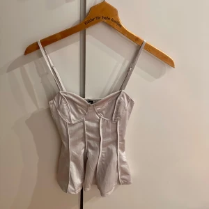 Grå korsettopp - Använd endast en gång, har ingen bild med den på men har en exakt likadan i vit så där ser ni! Det är en typ grå/beige färg som e jätte najs 🩷 Den är storlek XS och sitter ganska tajt på mig som brukar ha storlek S! 