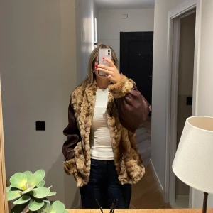 Skinnjacka med päls  - Världens finaste skinnjacka i vinröd färg med päls. Går att stänga framtill med hjälp av en ögla som du hakar i. Inga defekter, i nyskick. 