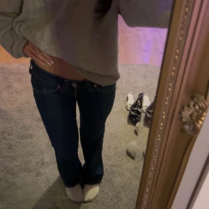 Mörkblå jeans Levis - Säljer ett par snygga mörkblå jeans i bra skick. Dessa är Levis jeans och är utsvänga där nere samt väldigt lågmidjade. Jeansen har en normal midja och är gjorda i ett slitstarkt denimtyg. Perfekta för höst och vår!
