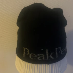 Svart mössa från Peak Performance - Snygg svart mössa från Peak Performance med broderad logga. Perfekt för kyliga dagar och en stilren look.
