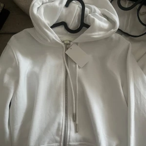 Vit hoodie med dragkedja - Vanlig vit hoodie/tröja. Aldrig använt och prislappen är kvar. Den är även helt ren. Skriv gärna till mig om ni har frågor eller vill kolla närmare på plagget ❤️