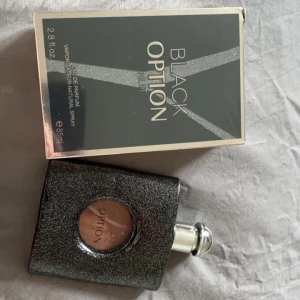 Black Option Nuit Eau de Parfum - Säljer en black opium parfym köpt i Polen, det är 85 ml. Den är öppnad och använd en gång bara men kände inte att doften passade mig❤️
