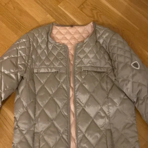 Beige quiltad jacka från Saki - Snygg beige quiltad jacka från Saki med dragkedja framtill. Jackan har en rund halsringning och två fickor med dragkedja på bröstet. Det är rosa färg inuti jackan. Perfekt för en stilren look. Perfekt jacka för hösten! Passa på. Ni kan buda på denna jackan men jag kommer att sätta ett pris till att börja med💓Storlek 34 alltså xs eller S💗