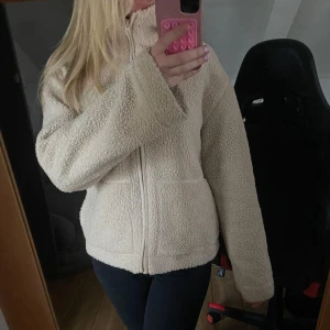 Beige teddyjacka med dragkedja - Mysig beige teddyjacka med dragkedja framtill. Slutsåld från hm och det lilla bandet som ska vara på dragkedjan är bortklippt som man kan se på sista bilden