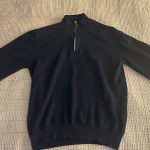 Stenströms quaterzip - Snygg marinblå quaterzip från Stenströms. Perfekt för en stilren look.Tröjan har långa ärmar och en ribbad kant vid ärmslut, nederkant och hals. Tröjan var i storlek L men krympte i tvätten då jag tvättade den för varmt så nu sitter den som S. 100% merino ull. Nypris på tröjan är 1999kr och mitt pris är 600!