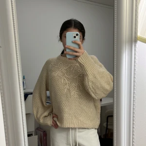 Beige stickad tröja med broderi - Säljer en mysig beige stickad tröja med vackert blommigt broderi på framsidan. Säljs inte längre