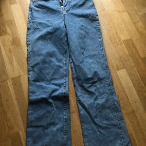 Blå jeans från Never Denim - Säljer ett par klassiska blå jeansbyxor från Never Denim. De är högmidjade med vida ben och knapp gylf. På 2 bilden har jag på mig samma modell fast en storlek större så man ser hur de ser ut på. De är välanvända men i bra skick och har endast lite slitage längst ner och på ena fickan (se bild 4/5), säljer då de är för små! Jag säljer även fler par i samma model! Nypris 599kr. Skriv gärna om du har frågor eller prisförslag! 🤗