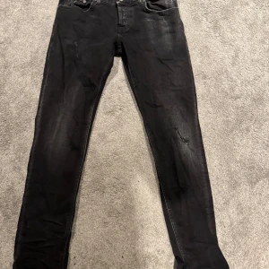 Svarta jeansbyxor - Snygga svarta jeansbyxor från dondup i en klassisk stil. De har en rak passform och är perfekta för en stilren look. Byxorna har en dragkedja och knappar framtill.