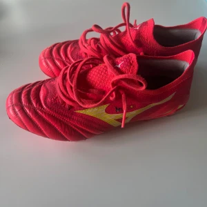  Mizuno morelia neo 4 - Snygga röda fotbollsskor från Mizuno. Skorna har en fin design med känguruläder på framsidan. Använda ca 1 månad annars i bra skick, finns några slitningar. Storlek 38   (24 cm)