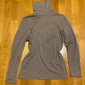 Polotröja - Säljer en stilren grå/beige/ljusbrun polotröja i 100% merinoull från Cubus. Tröjan har en klassisk polokrage och långa ärmar, perfekt för kyligare dagar. Den är mjuk och bekväm, vilket gör den till ett utmärkt val för både vardag och mer uppklädda tillfällen😻Står storlek M, men passar nog mindre också, beroende på hur tajt man vill att den ska sitta❤️Nypris 600kr!