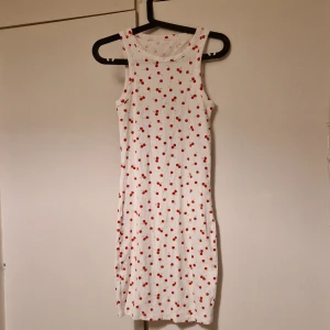 Vit klänning - Söt vit klänning med körsbärsmönster köpt från nelly förra året men aldrig använd endast provad på. Klänningen har en tight passform som går till mina knän nästan då jag är 1,63cm lång🥰🌸tror det är XS på storleken om jag inte minns fel