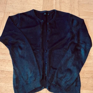 Svart kofta från Jeppson - Säljer en klassisk svart kofta från By Jeppson. Den har långa ärmar och knappar framtill. Perfekt för lager-på-lager under kyligare dagar. 🖤