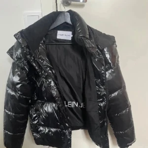 Svart pufferjacka från Calvin Klein - Snygg svart pufferjacka från Calvin Klein med glansig yta och huva. Jackan har en klassisk design med dragkedja framtill och är perfekt för kalla vintrar. Detta är för tillfället bara en intressekoll men är du intresserad så hör av dig😊 den är köpt här på Plick men var så gott som ny då och nu är den endast använd dem kallaste dagarna denna vinter💗 så den är i superfint skick