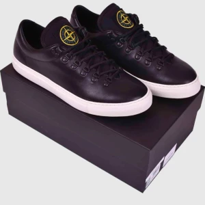 Svarta sneakers med vit sula - Oanvända Sneakers från Stone Island storlek 43,  Säljs för 2.500 Kr alt byte.  Nypris ca 5.500 Kr  Kartong ink extra vita skosnören ingår.  En sneaker från italienska Stone Island.  Sneakern stängs med snörning och har märkets ikoniska logotyp broderad på den svarta plösen. Sneakern är tillverkad av läder på såväl utsida som insida och har en gummisula