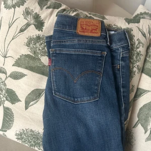 Blå jeans från Levi's - Säljer ett par snygga blå Levi's jeans, modell 710 Super Skinny. De har en klassisk femficksdesign och är perfekta för en stilren look. Passar bra till både vardag och mer uppklädda tillfällen. Aldrig använda eftersom dem har alltid varit för små därför säljer för en billig slant. Är mer blå i verkligheten än på bilderna! 😊