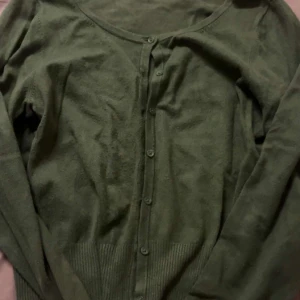 Grön kofta från Target Collection - Säljer en grön kofta från Target Collection. Den har långa ärmar och knappar framtill. Perfekt för lager-på-lager under kyligare dagar. 💚