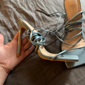 Blå klackskor med snörning - Snygga blå klackskor med fyrkantig tå och elegant snörning som går upp runt vristen. Perfekta för att ge en stilren touch till din outfit.