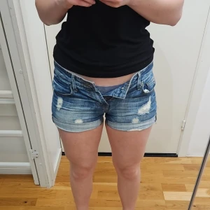 Låga jeansshorts - Lågmidjade blå jeansshorts med blekning och slitningar, extremt fina. Normala i storlek - 38cm tvärs över, 79 runt om hela! Storlek XS, perfekta till i sommar 💕