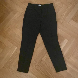 Svarta byxor från H&M - Snygga svarta byxor från H&M i en klassisk stil. De har en rak passform och är perfekta för en stilren look. Byxorna har hällor för bälte och diskreta bakfickor. Perfekta för både vardag och mer formella tillfällen.