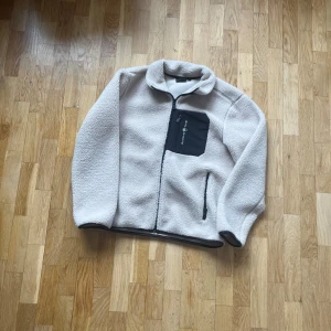 Beige fleecejacka från Sail Racing - Säljer en mysig beige fleecejacka från Sail Racing. Perfekt för kyliga dagar och ger en skön och avslappnad stil. Modellen är 177 så för en bra passform skulle jag säga runt 170, ny pris 1200kr Priset är inte hugget i sten. För mer bilder eller funderingar är det bara och skriva 