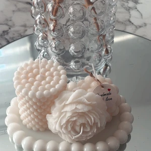 Vita dekorativa ljus - Säljer två vackra vita ljus, ett med pärlstruktur och ett format som en ros. Perfekta för att skapa en mysig atmosfär i hemmet. Ljusen är handgjorda och kommer med en fin etikett. Perfekt som present eller för egen dekoration.