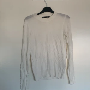 Vit långärmad tröja från 157 - Säljer en stilren vit långärmad tröja från 157. Perfekt för en enkel och klassisk look. Tröjan har en rund halsringning och är tillverkad i ett mjukt material som känns skönt mot huden.