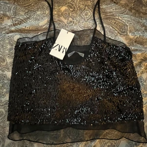 Festtopp från zara - Snygg festlig topp från zara, helt oanvänd med prislapp kvar💕lite mindre i storleken så skulle säga S, tror ej den finns att köpa längre 