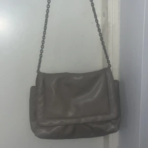 Grå/beige axelväska från H&M - Köpt på vinted för ett tag sedan men oanvänd av mig. Hål och fläckar på insidan (sista bilden) men inget fel på utsidan☺️Väldigt rymlig