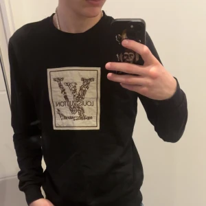 Svart långärmad tröja från Louis Vuitton - Snygg svart långärmad tröja från Louis Vuitton med ett stort logotryck på framsidan. Perfekt för en stilren look. Tröjan har en klassisk passform och rund halsringning. Den är i storlek S köpte den för 6 månader sedan men jag tror jag har använt den max 3/4 gånger då den bara ligger i min garderob 