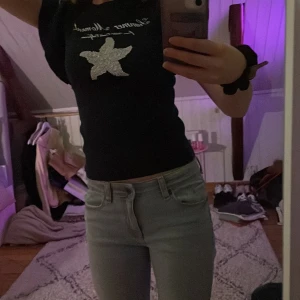 Marinblå t-shirt med volangärmar - Säljer en marinblå t-shirt med en glittrig stjärna på framsidan. T-shirten har volangdetaljer på ärmarna och är perfekt för en avslappnad stil. Jättefin somrig topp. Aldrig använd.