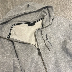 Grå zip hoodie från Sail Racing - Säljer en grå zip hoodie från sail racing. Jättesnygg och knappt använd, i nyskick och inga defekter. Köpte för 999. Pris kan diskuteras 
