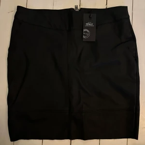 Kjol o fakeläder  - Helt ny. Dragkedja i bak och fickor. Ny med prislapp.