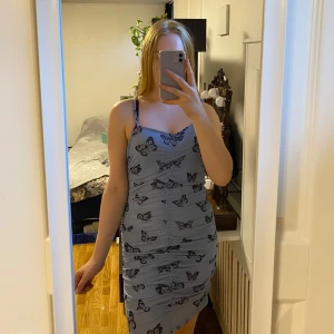 Blå fjärilsklänning, s - Man får bra former i den här, m