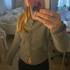Grå stickad kofta från Zara - Hej säljer denna jättefina kofta från zara som tyvärr inte kommer till användning längre, Koftan är i bra skick förutom 2 knappar som sitter väldigt löst där av priset. Men har själv sytt på knappar på koftan och de är lätt att sy ihop med nål o tråd