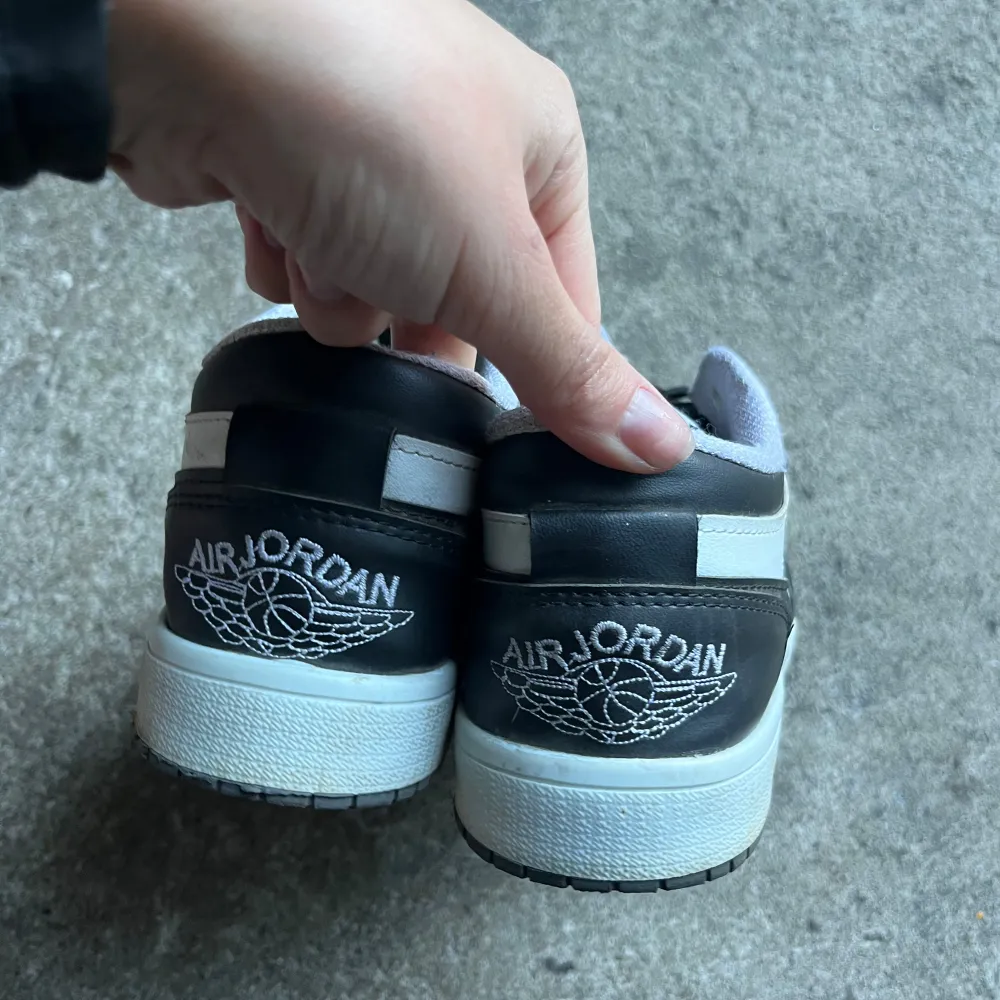 Säljer ett par snygga svartvita Nike Air Jordans. De har en klassisk design med svart snörning och perforerade detaljer på tån. Skorna är i bra skick och perfekta för både vardag och fest. De har den ikoniska Air Jordan-loggan på hälen.. Skor.