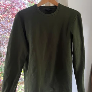 Olivgrön långärmad tröja från COS - Säljer en stilren olivgrön långärmad tröja från COS. Tröjan är i gott skick
